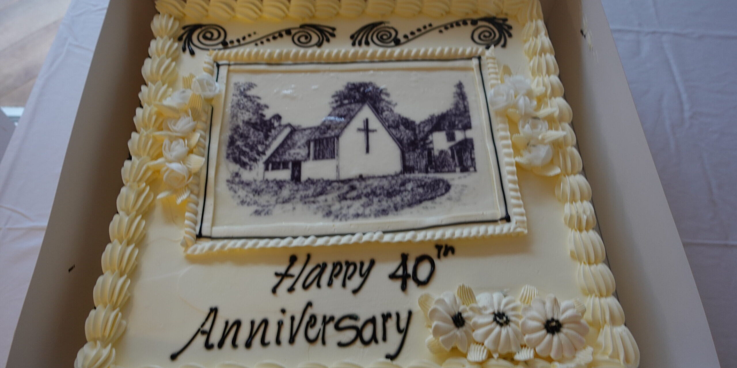 A large sponge cake decorated with an image of the chapel at Whitgift House