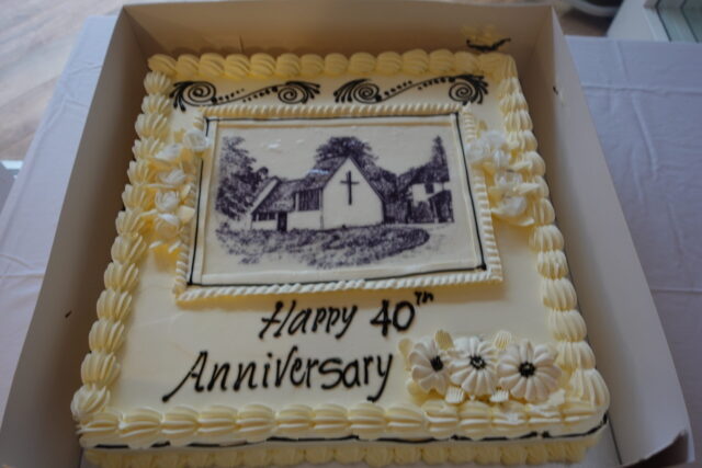 A large sponge cake decorated with an image of the chapel at Whitgift House