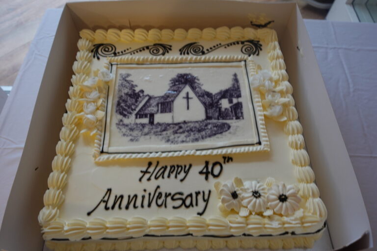 A large sponge cake decorated with an image of the chapel at Whitgift House