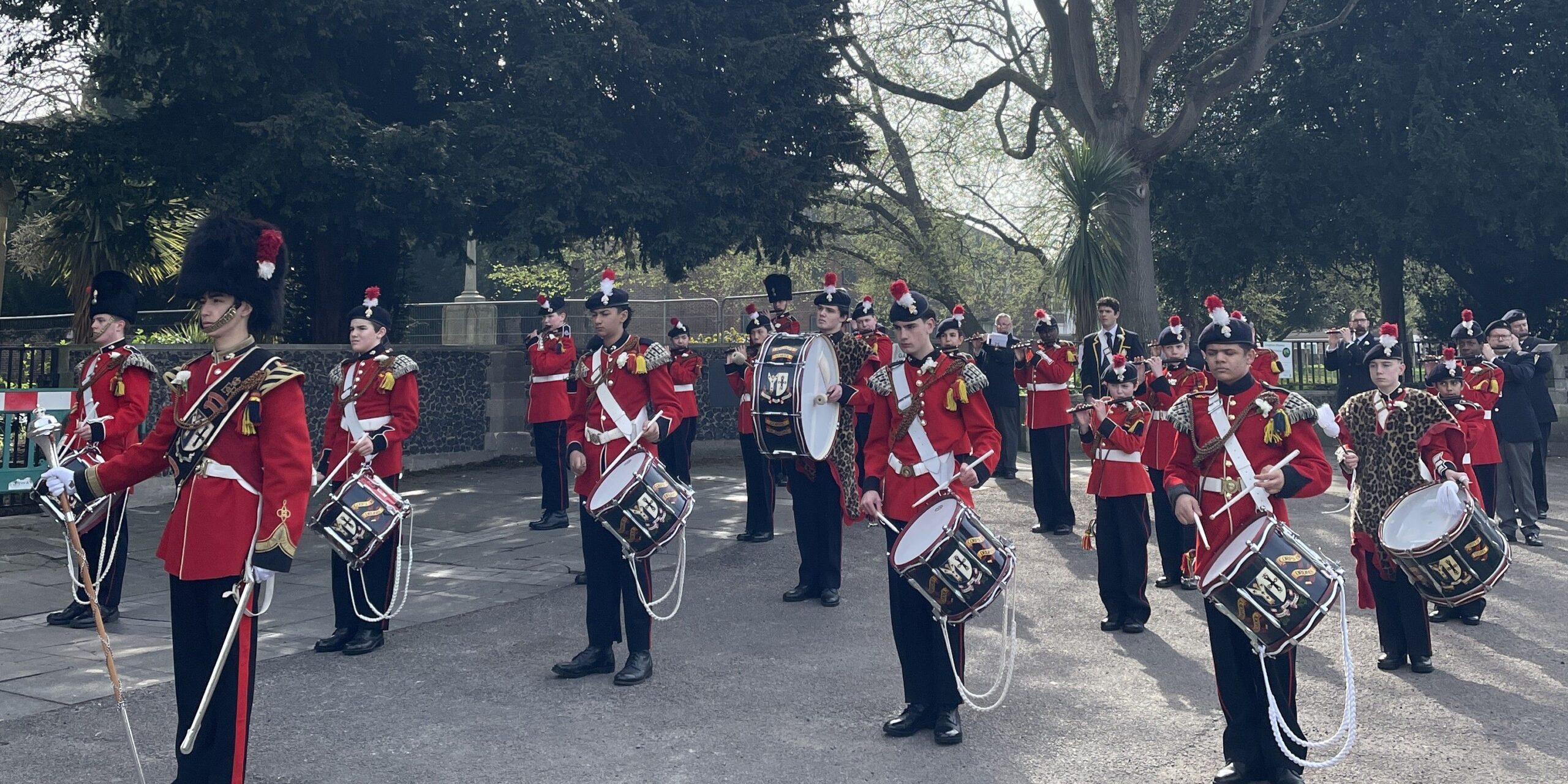 Whitgift School Corps of Drums comprises students dressed in red and black uniforms and bearskin hats.