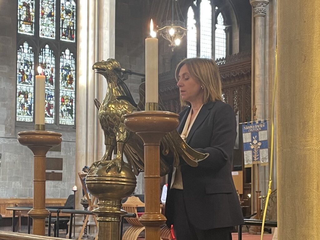 A smartly dressed woman stands at the Eagle Lectern in Croydon Minster