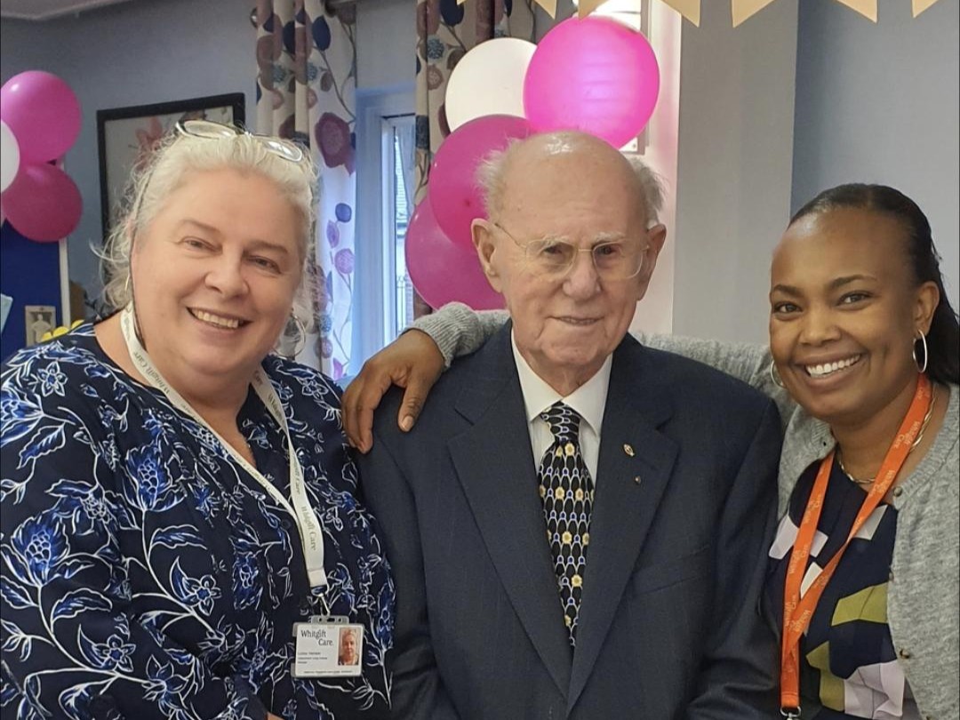 Harold smiles as he has his photo taken with Whitgift Care staff Liuba (left) and Mercy (right)
